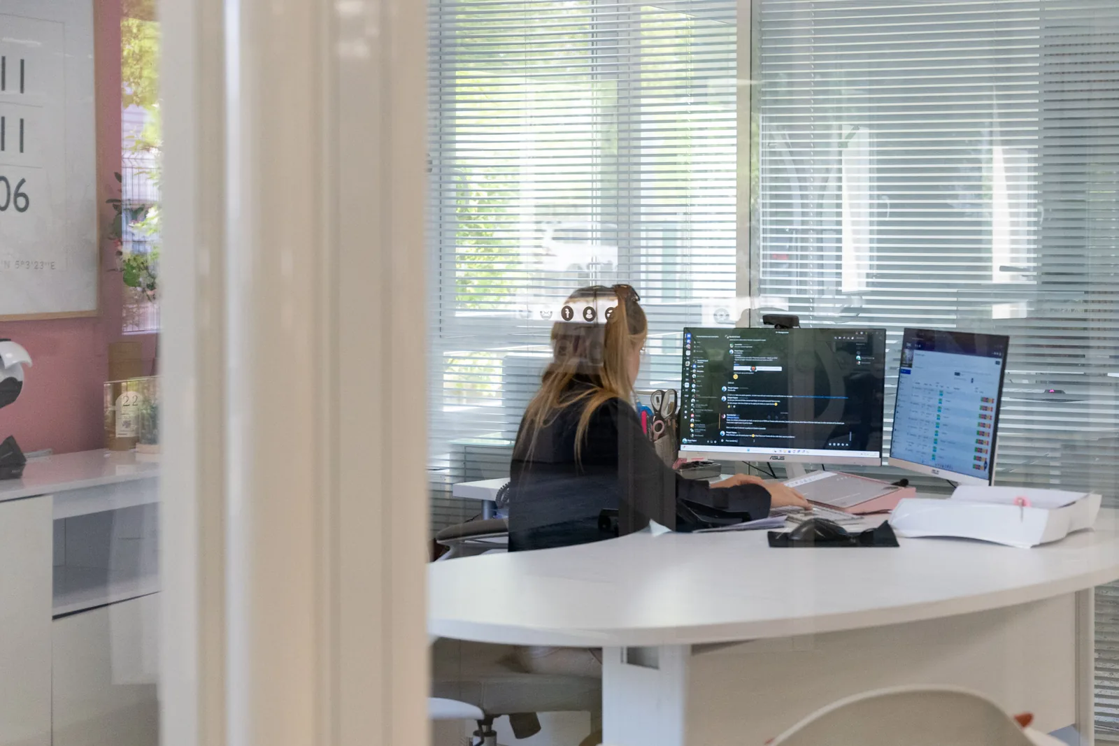 Une collaboratrice au travail dans un bureau vitré de BWA